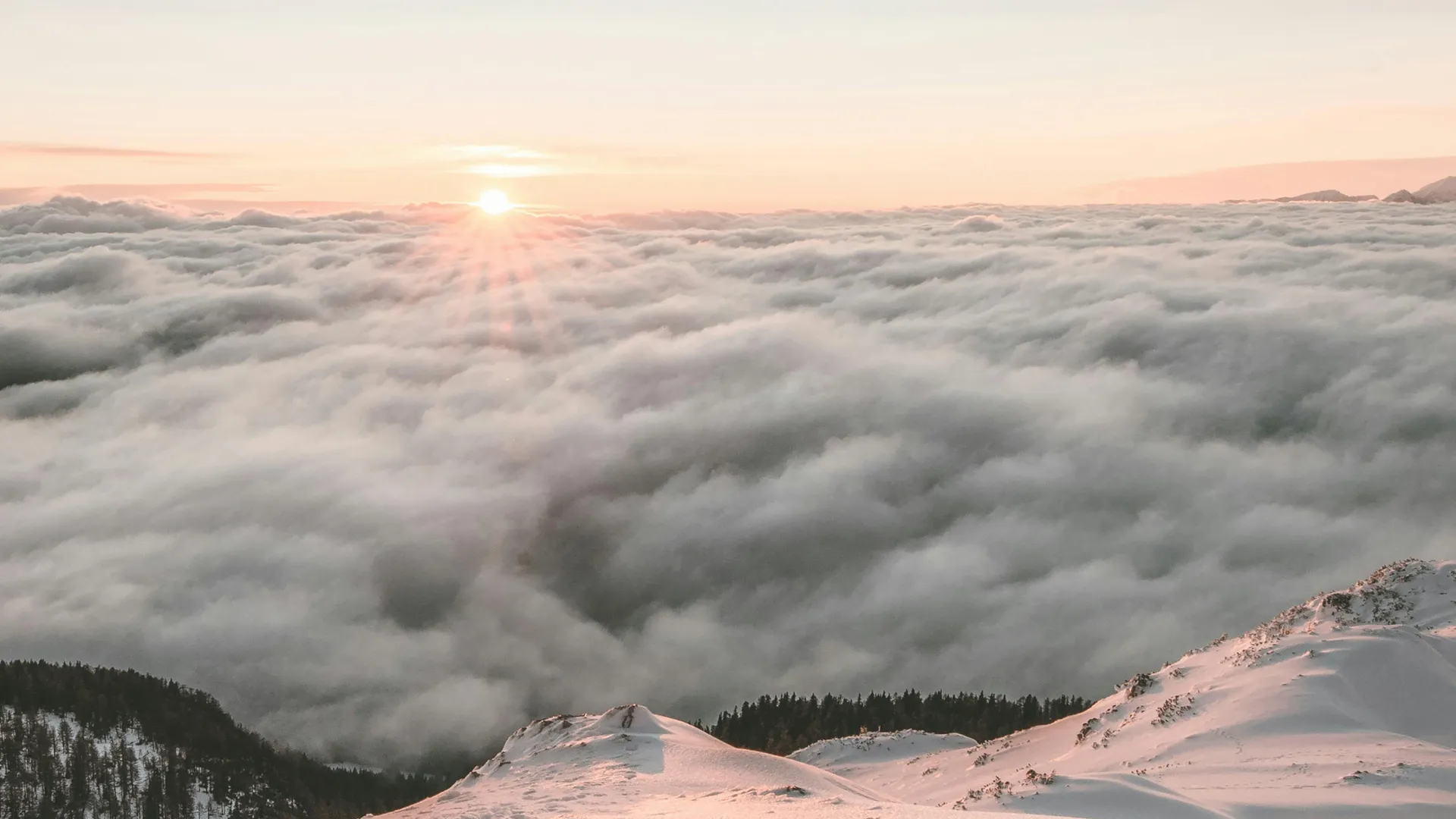 Sunset peeking through the clouds on a tall mountain