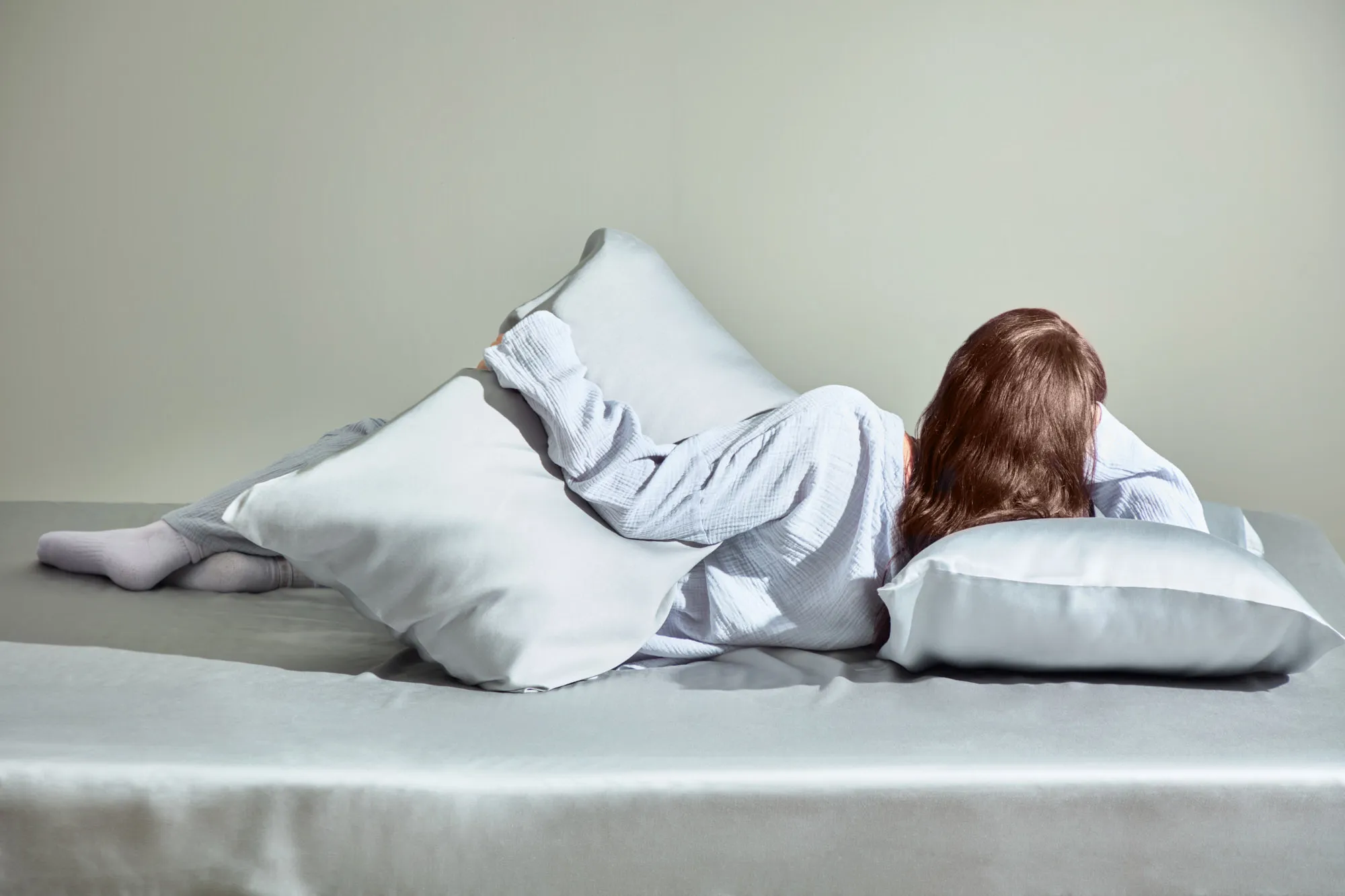 Woman sleeping on a a comfy bed with a pillow and blanket